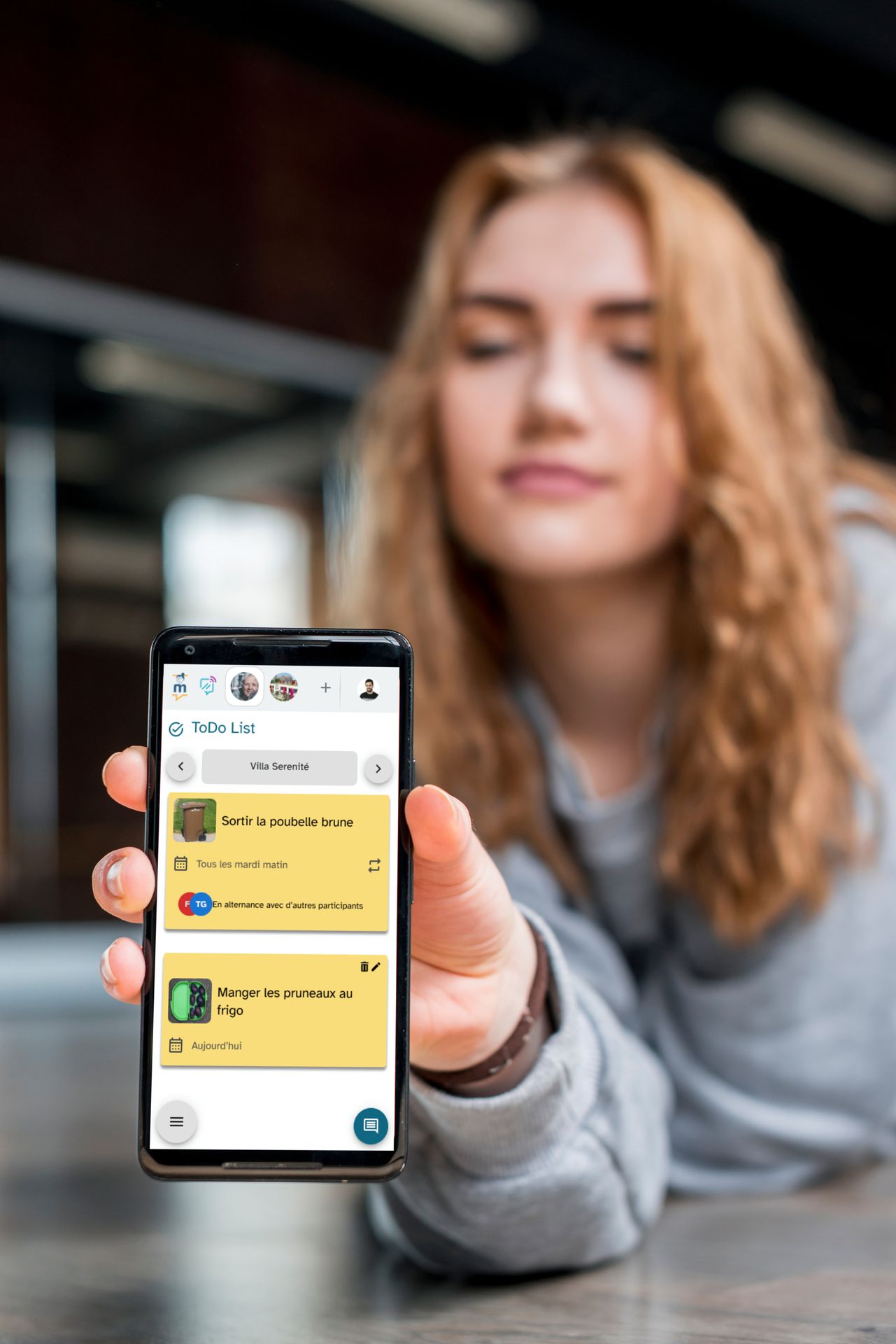 Une aidante familiale qui montre l'application Marcel pour échanger ou téléphoner avec ses proches